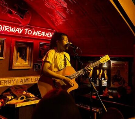 Man playing guitar in Bad Bads, red light and small stage in one of the best pubs in Temple Bar