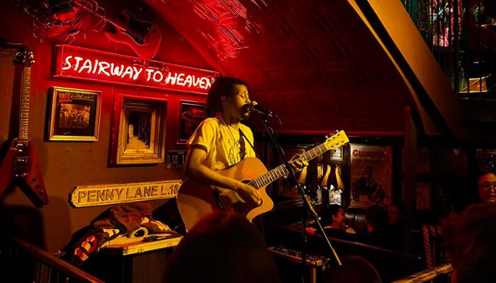 Man playing guitar in Bad Bads, red light and small stage in one of the best pubs in Temple Bar